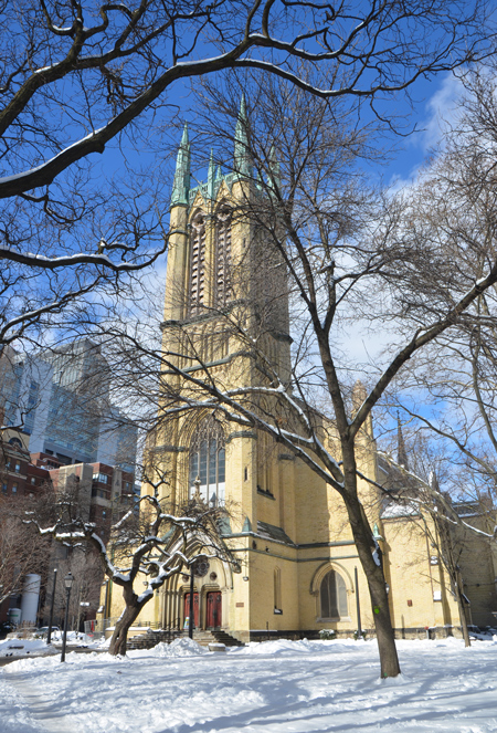 front of Metropolitan United Church, with the snow covered park in front, snow, large trees, red door 