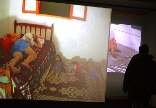 a person watching a large video display in an art gallery