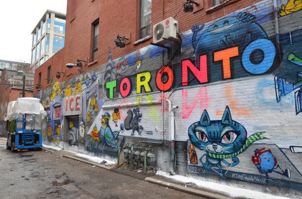 most of a new mural by uber5000 in Graffiti Alley based on winter activities at Nathan Phillips Square 