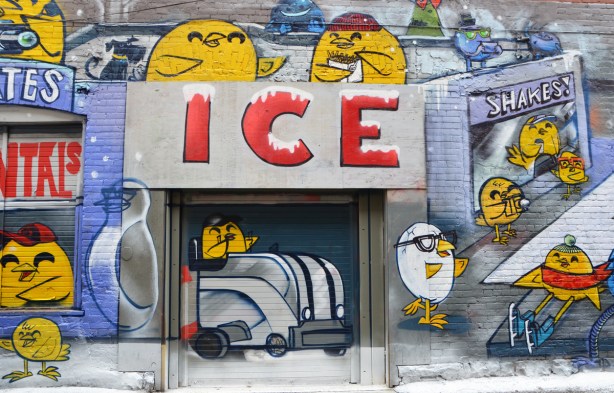 part of a winter themed uber5000 mural, yellow birdie about to drive a zamboni out of its garage, other yellow birdies looking on, a birdie that looks like a cracked egg. 