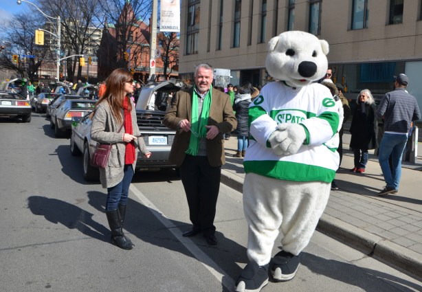 Carlton, the Maple Leafs hockey team mascot in a St. Pats jersey waiting for the parade to start, working the crowd. 
