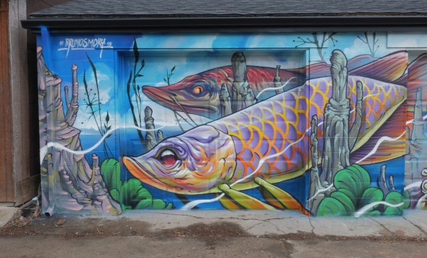 mural by Bruno Smoky, part of it, two large fish swimming under water. 