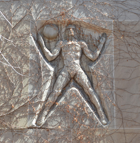 on a wall, covered with ivy plant (early spring so no leaves), relief sculpture of a man with legs spread apart, with a ball on his shoulder, arms bent upwards at elbow