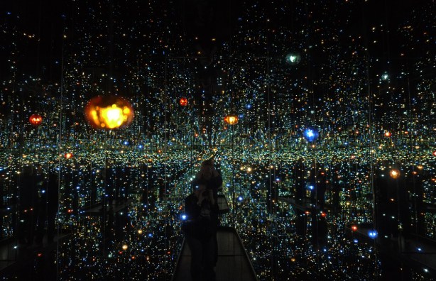 dark room with lights that look like planets and stars, mirrors on walls and ceiling. 
