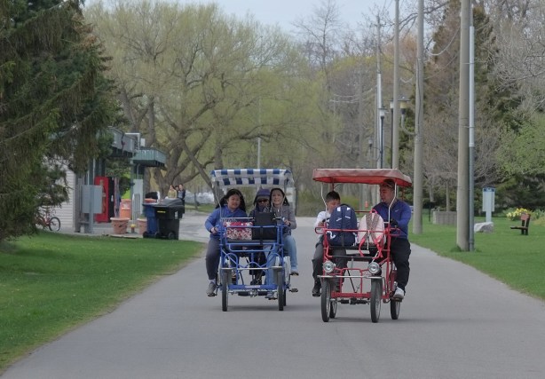 people cycling in 2 quadricycles, a four wheeled bicycle like vehicle, on paths, 