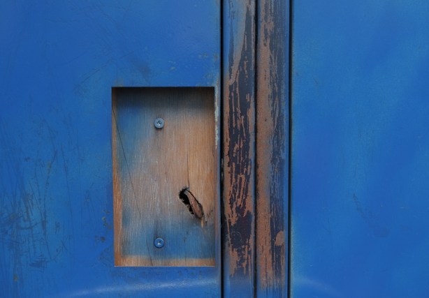 blue abstract from two blue doors with cut out where handle should be 