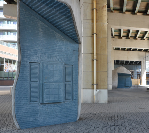 blue surface, window relief sculpture in it, other side is artifical rock, under the Gardiner Expressway, lock stone ground, 