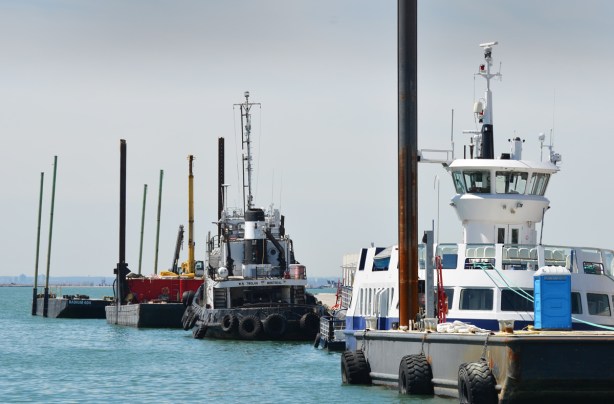small boats lined up along a dock, tugboat,