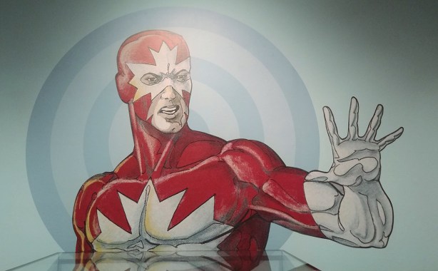 painting of Captain Canuck, from the chest up, one arm raised to shoulder height
