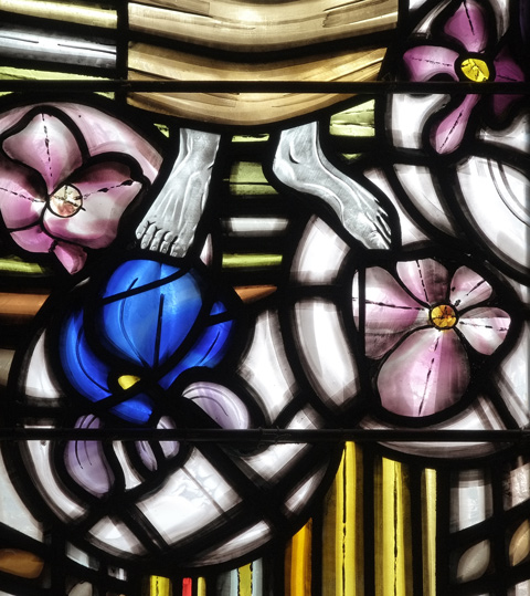 detail of stained glass window, feet and large pink and blue flowers. 