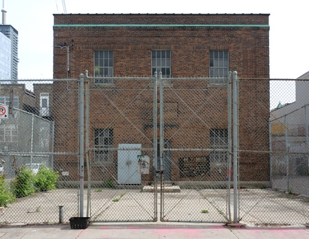 chainlin fence and gate around on old two storey brick building that was part of Toronto Hydro 
