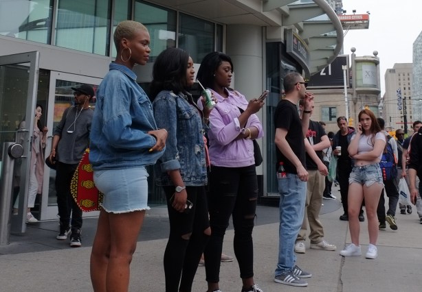 women and men standing outside the Eaton Centre on Yonge street 