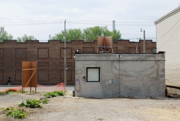 vacant lot with one small concrete structure on it, one small window in the back of it. 