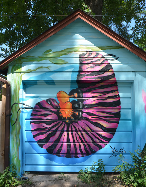 a large pink and black caterpilar curled up on a garage door - mural 
