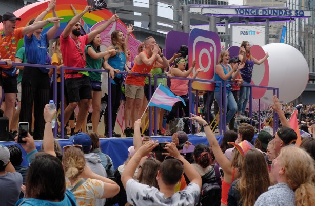 prid eparade float passes by a crowd, lots of shouting and cheering 