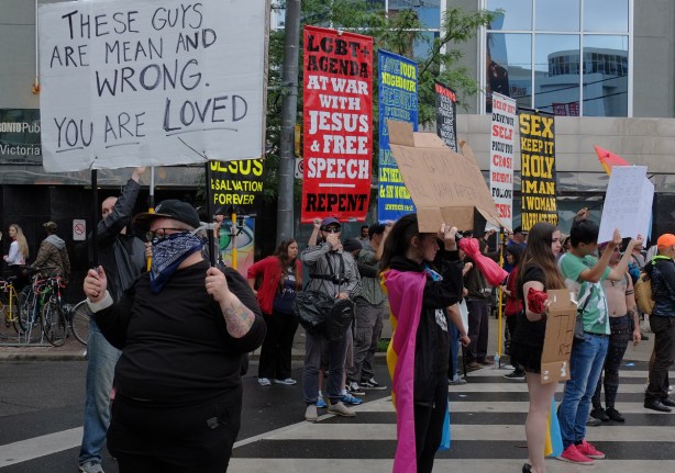 protest signs and counter protest signs at the prode parade 