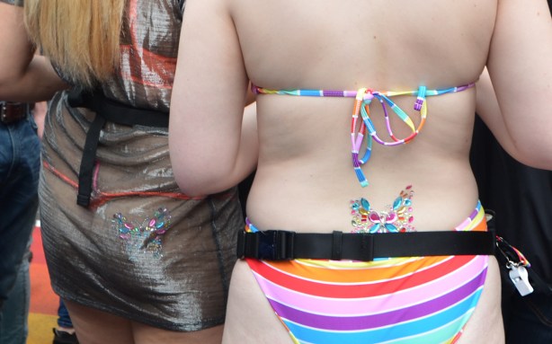 two women in bikinis, both with sparkly butterflies on their lower back 
