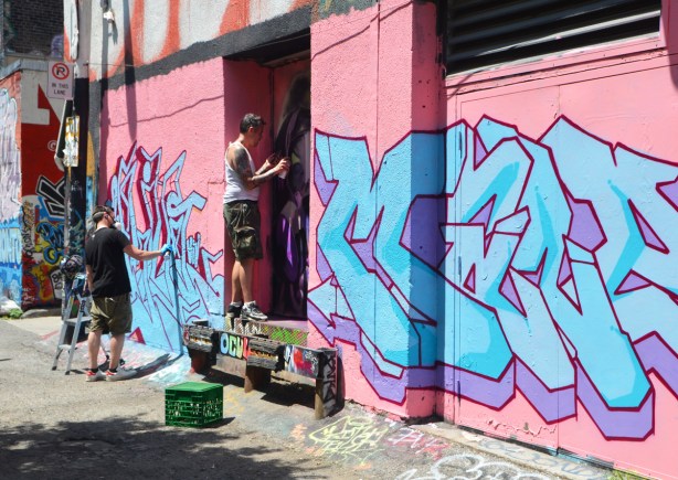 a street art piece in progress, man spray painting, 