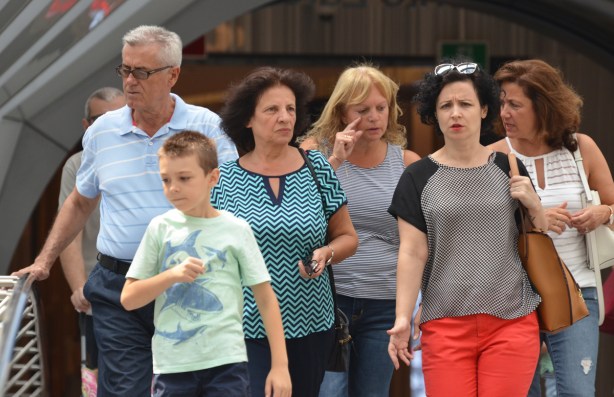 a group of people walking over the raised pedestrian bridge between the Eaton Centre and the Bay, 4 women, one man and a boy 