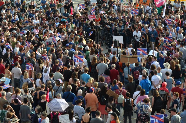 crowd gathered at Nathan Phillips square for a protest, TV cameras, microphones, speakers, protesters, signs, placards, 