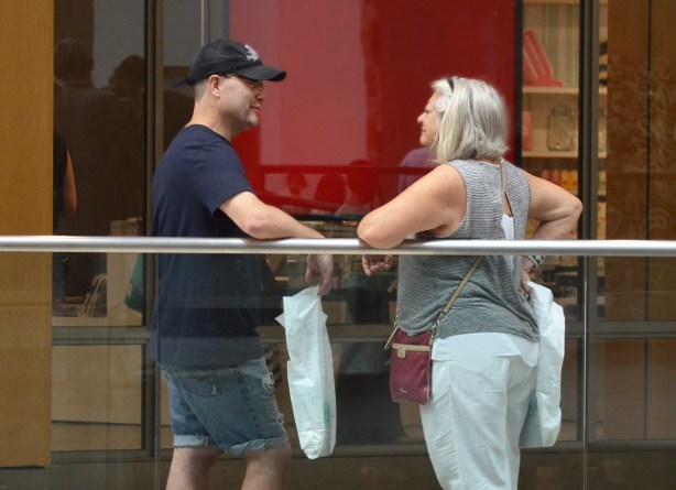 a couple standing facing each other, talking to each other, 