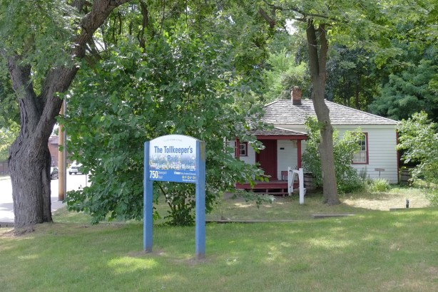 The Tollkeeper's Park, sign, green space, trees, and an old small wood frame house, now a museum,