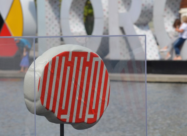 2 dimensional brain, artwork, designed with orange and white lines, beside water at Nathan Phillips Square, 3D toronto sign behind it