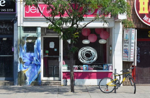 front window of Jelly, a modern doughnut store on Queen West, small tree in front of it 