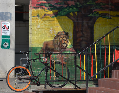 a bike is parked beside a mural with a lion on it 