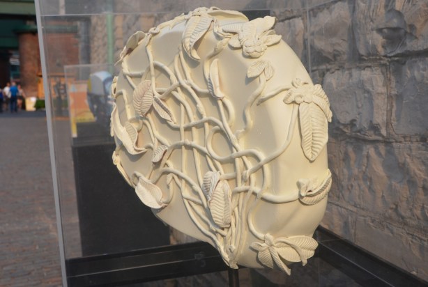 off-white artwork in the shape of a brain, covered with cords and leaves, or maybe leaves and stems