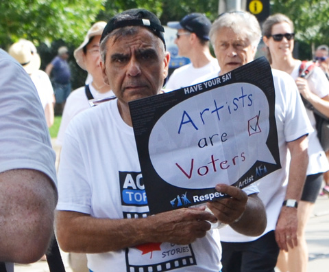 labour Day parade on Queen St West, ACTRA member male, carrying sign that says Artists are Voters, 