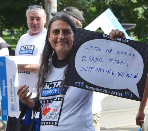 labour Day parade on Queen St West, ACTRA member, female, with sign that says Come on Women, please start supporting other women 
