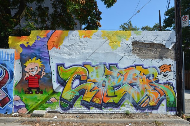  in a popart mural by Matt Gondek and Jackson, in an alley, calvin and hobbes and some text in between 