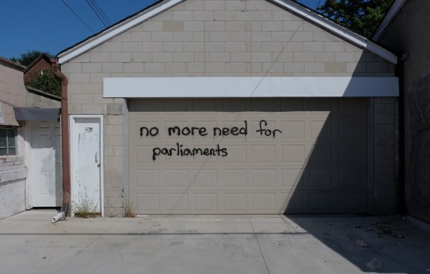 a beige garage door with the words no more need for parliaments written on it 