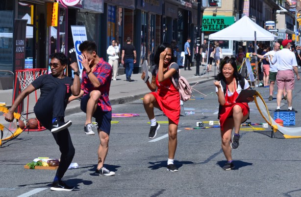 four young people dancing in the street, two male and two female. 