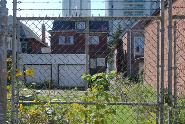 chainlink and barbed wire fence acorss the backyard of a house