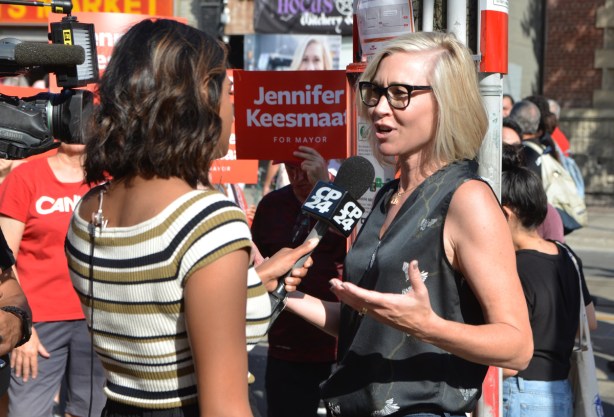 labour Day parade on Queen St West, mayoral candidate Jennifer Keesmaat being interviewed by a woman reporter from CP24 news, in the midst of the parade 