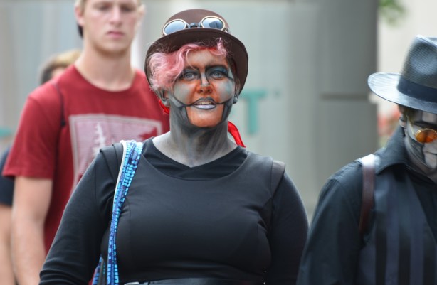 a woman in costume, black top, har, and face paint,