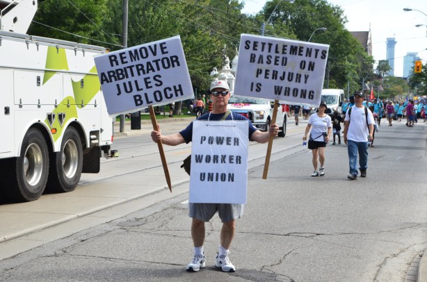 Power Workers union protest signs, held by one man 