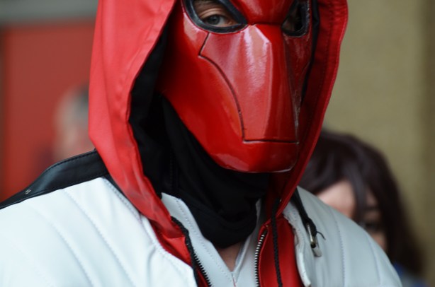 man in red leather mask, holes for eyes but nothing else,