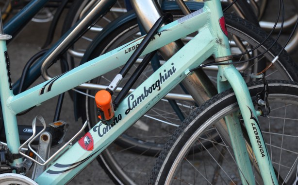 turquoise Lamburghini bike locked along with other bikes