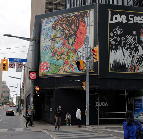 mural above the sidewalk, as people walk by, Yonge Street street sign, traffic,