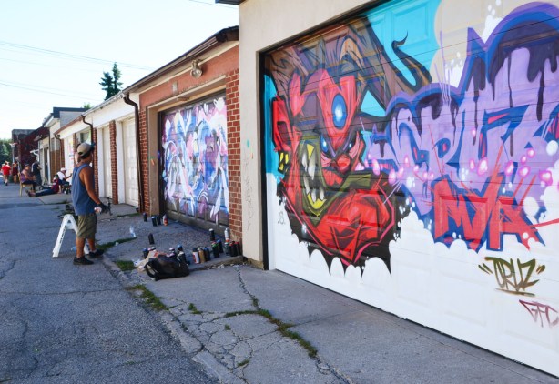 garage doors being painted with street art murals, laneway