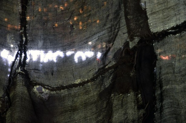 looking at the back of the 3D Toronto sign at Nathan Phillips, looking through burlap and tarps that have been stitched together