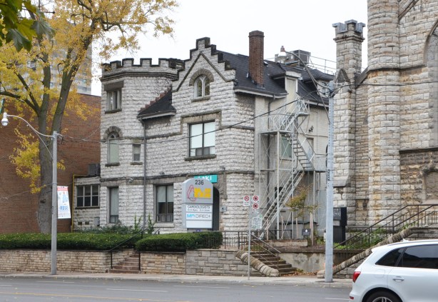 stone building, with castle like features, former Church of the Messiah Rectory on Avenue Road, now office building and medical clinic. Three storey grey stone