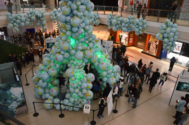 piles of inflatable globes are arranged at Scarborough Town Centre, people are walking around them and through a tunnel made of them