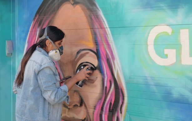 spray painting the eye on a mural