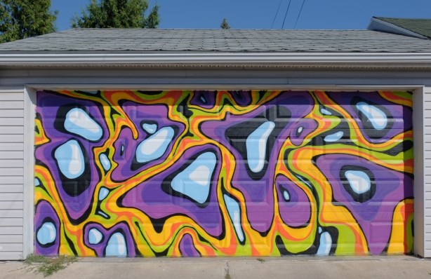 mural on a garage door of white, orange, and purple blobs and squiggles