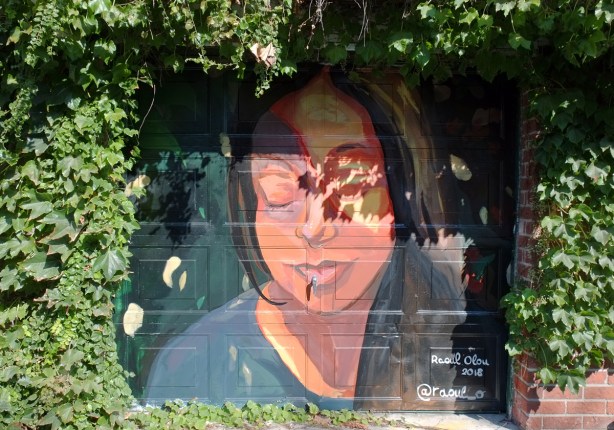 finished mural of a woman's face, with her eyes closed 