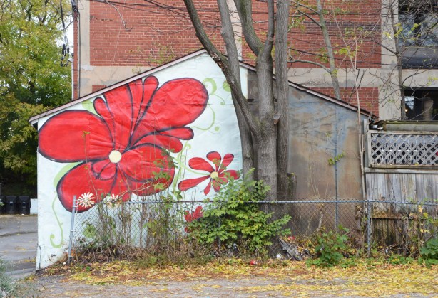side of a garage painted with a couple of large red flowers